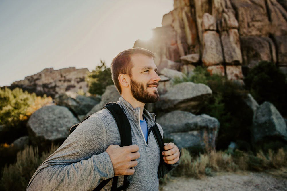 Man hiking on a trail surrounded by nature to support mental health and well-being.