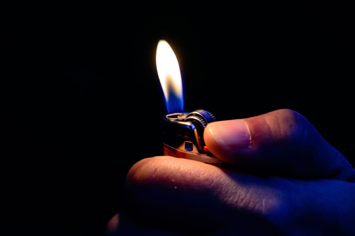 Man holding a lighter, preparing to use a dab