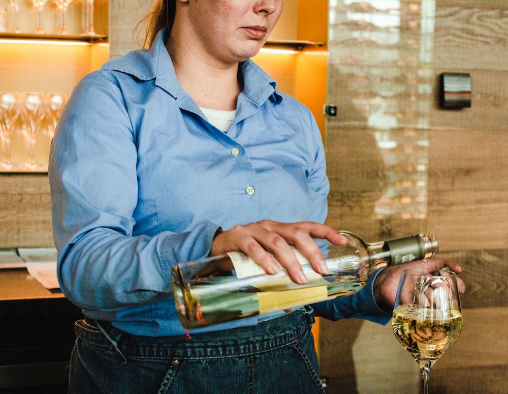 Woman pouring wine as potential factor in urinary tract health.