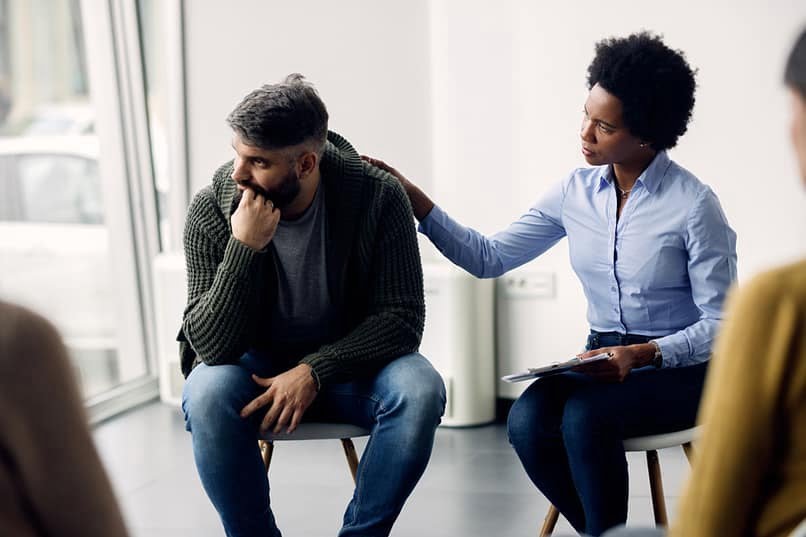 Woman supporting man during group therapy, discussing molly vs ex