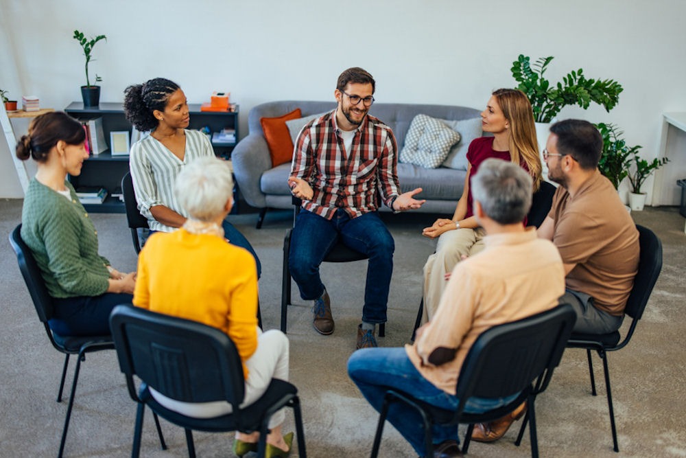 a diverse group sitting in chairs for therapy discussing speedball addiction