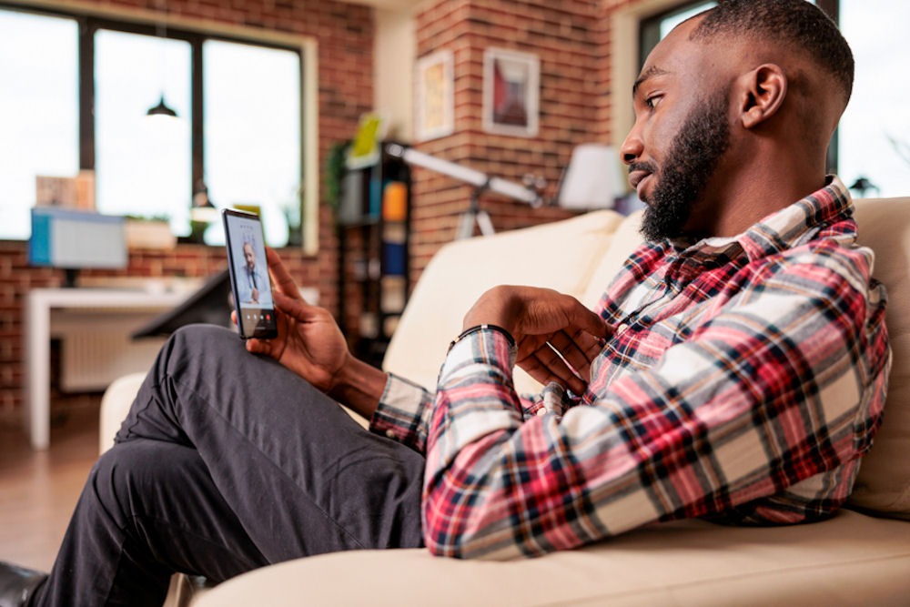 man sitting on chair with his phone in rehab