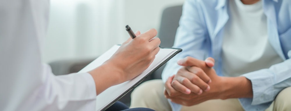 Therapist taking notes during a session on addictive thinking