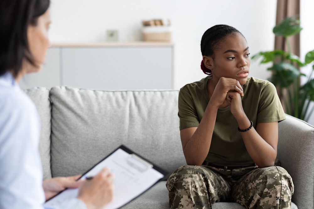 Woman in the military sitting on a couch for therapy at Recovery Integrity