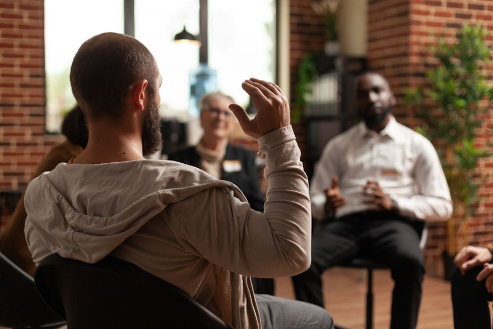 Individuals sharing experiences on how community support helps mental health recovery