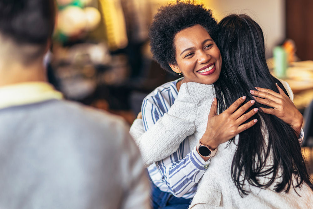 Two adults warmly embracing in a supportive setting, illustrating connection and care relevant to inpatient rehabilitation.