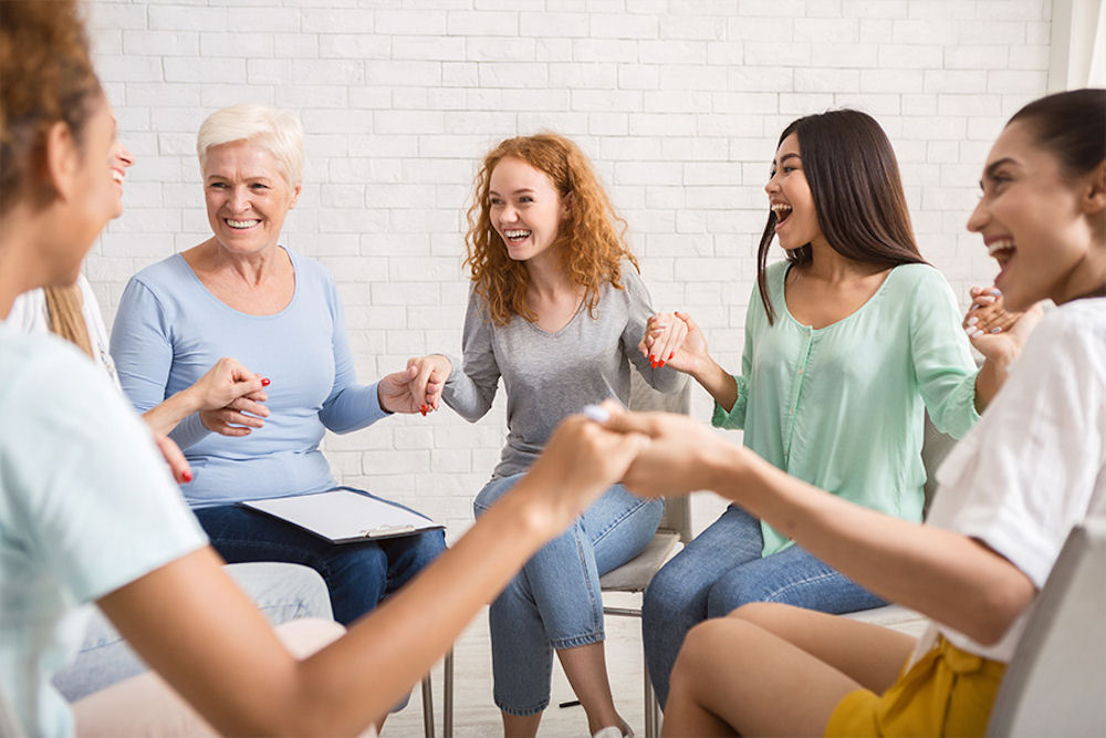 a-group-of-women-holding-hands-in-therapy
