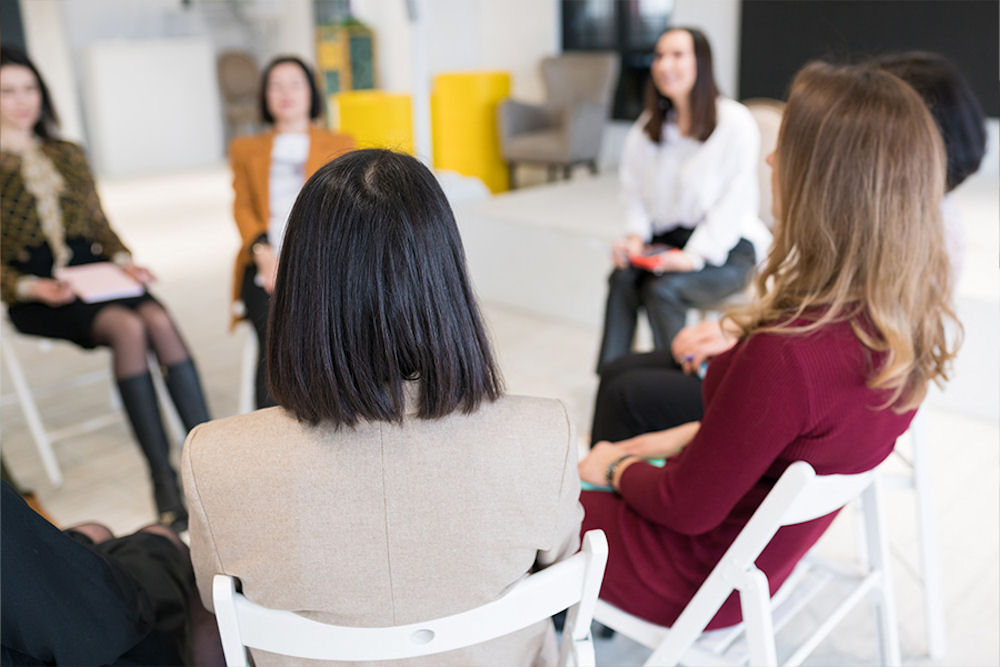 a group of women sitting in therapy